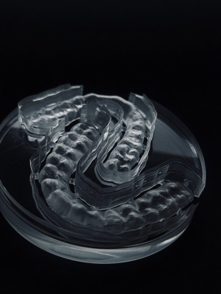 Guardas oclusales fresadas en PMMA de grado dental, transparentes, en placa de Petri sobre fondo negro